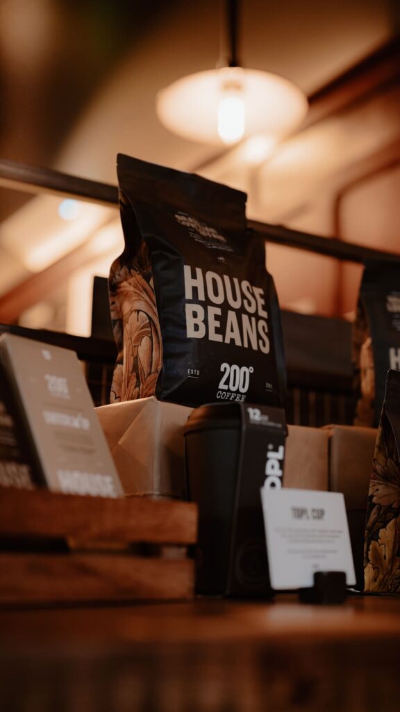 A bag of 200 Degrees House Beans coffee on the counter of a coffee shop