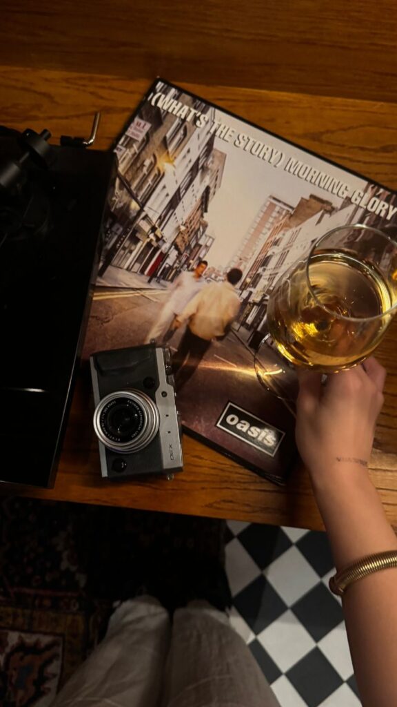 Camera, record sleeve and a glass of wine on a bar table