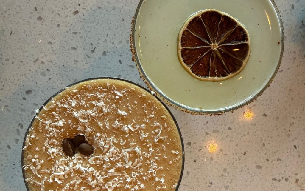 Two cocktails photographed from above on a terrazzo table